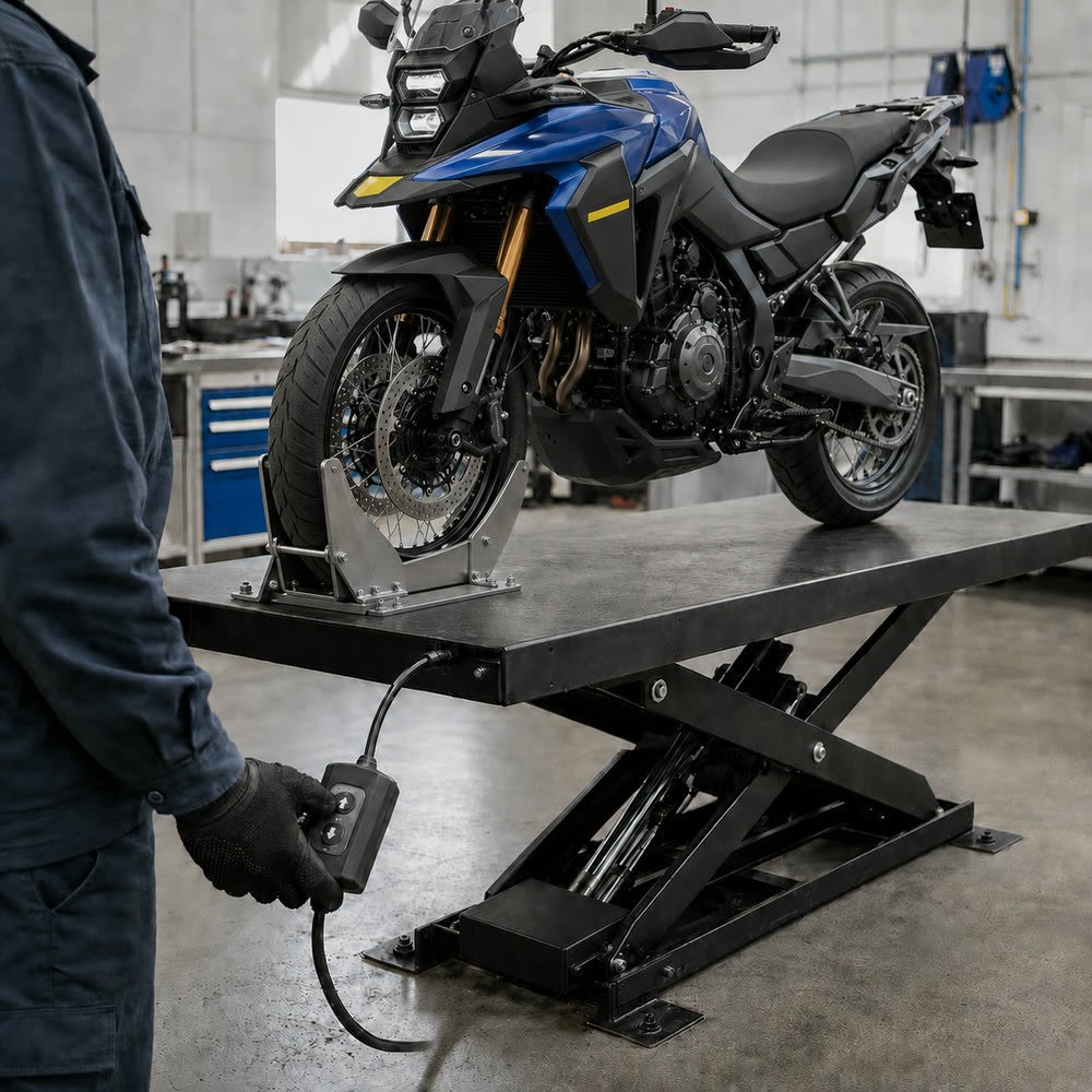 Mavi Suzuki motosiklet atölye liftinde; teknisyen lift kumandasını tutuyor.